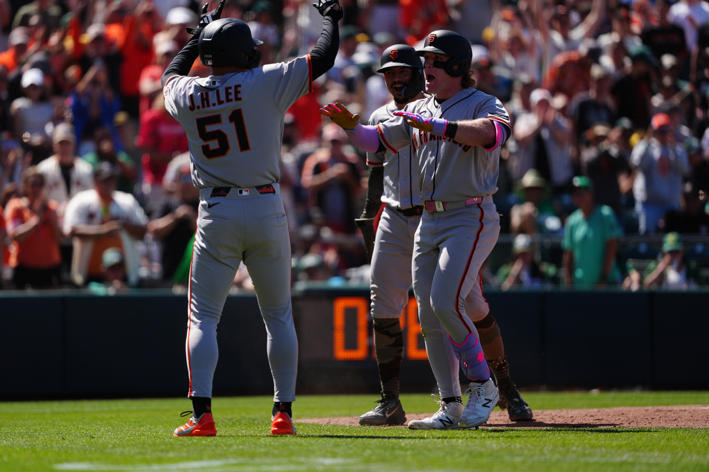 San Francisco Giants' Harrison Bader, front right, is greeted at home plate by Jung Hoo Lee (51) after hitting a grand slam in the eighth inning of a baseball game against the Athletics, Sunday, May 17, 2026, in West Sacramento, Calif. (AP Photo/Alan Greth)