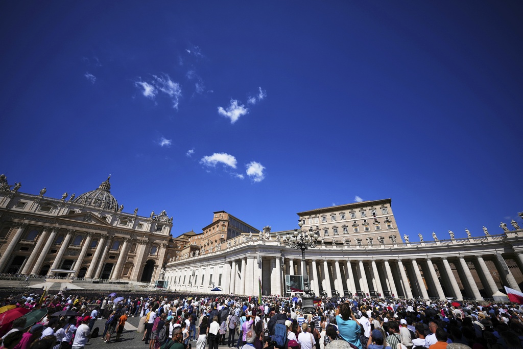 People gather as Pope Leo XIV delivers his blessing while he recites the Angelus noon prayer from the window of his studio overlooking St.Peter's Square, at the Vatican, Sunday, Aug. 31, 2025. (AP Photo/Andrew Medichini)