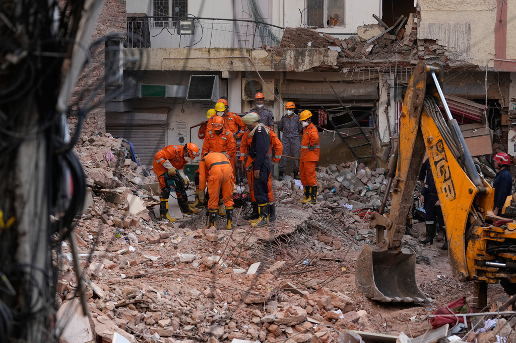 Rescue workers continue to search for people trapped under the debris of a collapsed building in New Delhi, India, Monday, Sept. 7, 2026. (AP Photo/Manish Swarup)