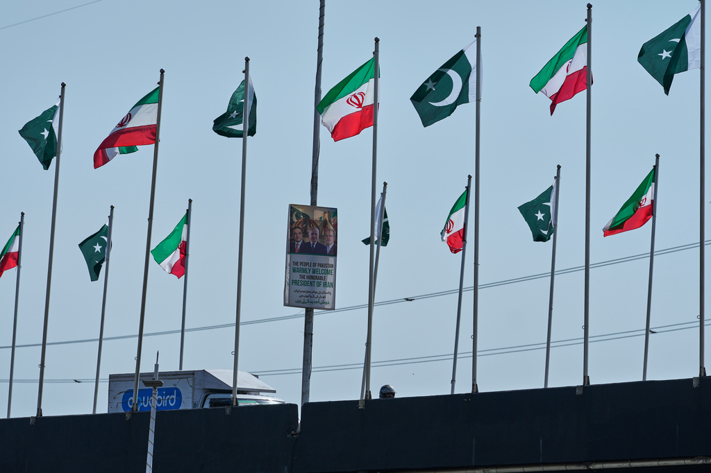 The welcoming billboard, featuring Iranian President Masoud Pezeshkian, right, with Pakistan President Asif Ali Zardari, center, and Prime Minister Shehbaz Sharif, is displayed alongside of an overhead bridge, in Islamabad, Pakistan, Tuesday, June 23, 2026. (AP Photo/Anjum Naveed)