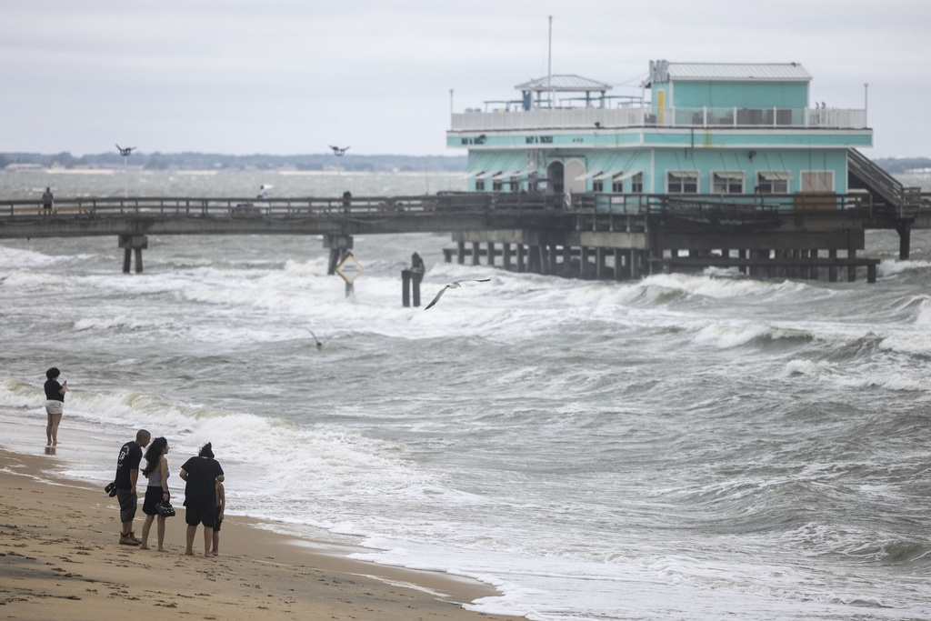 People take to the beach in high winds and rough surf as a result of Hurricane Erin near the Ocean View Fishing Pier in Norfolk, Va., Thursday, Aug. 21, 2025. (Kendall Warner/The Virginian-Pilot via AP)