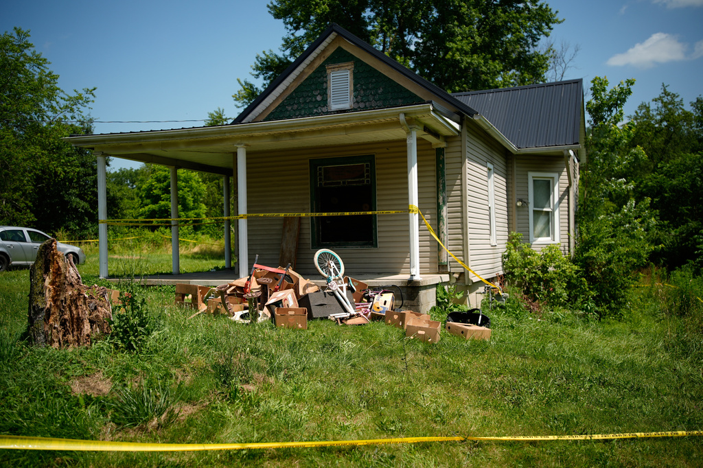 Police tape surrounds a home where authorities say they removed 16 children and arrested four adults in Hamden, Ohio, Wednesday, July 1, 2026. (AP Photo/Carolyn Kaster)