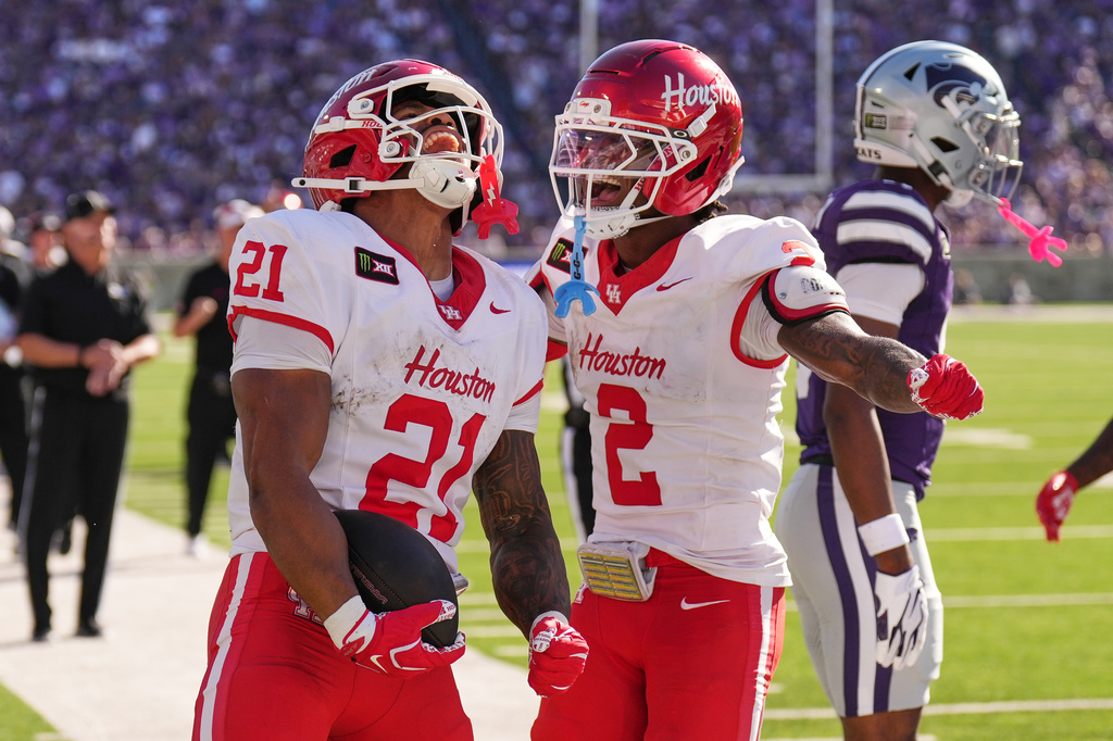Houston running back Makhi Hughes (21) celebrates with Houston wide receiver Koby Young (2) after scoring a touchdown during the first half of an NCAA college football game against Kansas State, Saturday, Oct. 10, 2026, in Manhattan, Kan. (AP Photo/Charlie Riedel)
