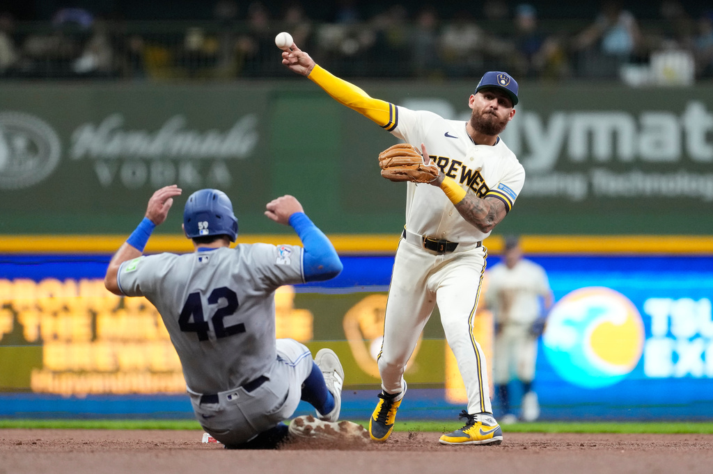 Milwaukee Brewers' Joey Ortiz, right, throws to first base to turn a double play after tagging Toronto Blue Jays' Brandon Valenzuela, left, out at second during the third inning of a baseball game Wednesday, April 15, 2026, in Milwaukee. (AP Photo/Aaron Gash)