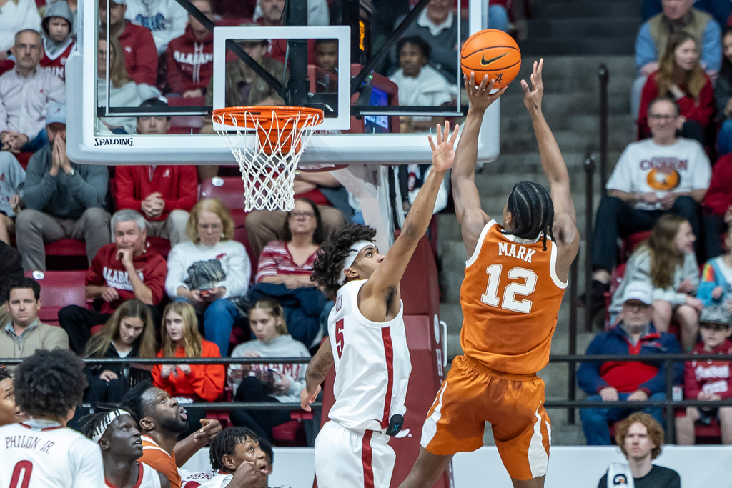 Alabama forward Amari Allen (5) challenges a shot by Texas guard Tramon Mark (12) during the first half of an NCAA college basketball game Saturday, Jan. 10, 2026, in Tuscaloosa, Ala. (AP Photo/Vasha Hunt)