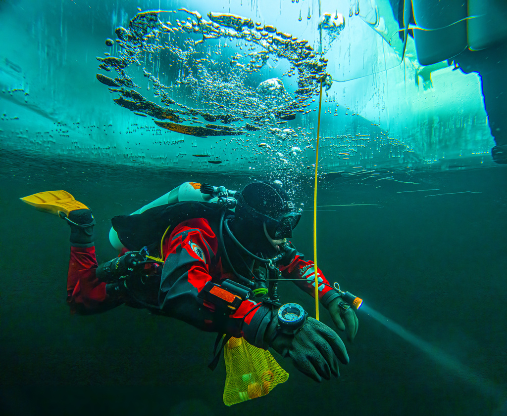 In this photo provided by Pata Degerman, a diver swims under the ice during a Polar Scientific Diving class in Kilpisjärvi, Finland, March 13, 2024. (Pata Degerman via AP)