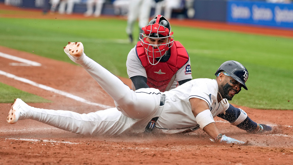 Tampa Bay Rays' Yandy Díaz, front, scores ahead of the tag by Boston Red Sox catcher Mickey Gasper on a sacrifice fly by Ryan Vilade during the fifth inning of a baseball game Wednesday, June 10, 2026, in St. Petersburg, Fla. (AP Photo/Chris O'Meara)