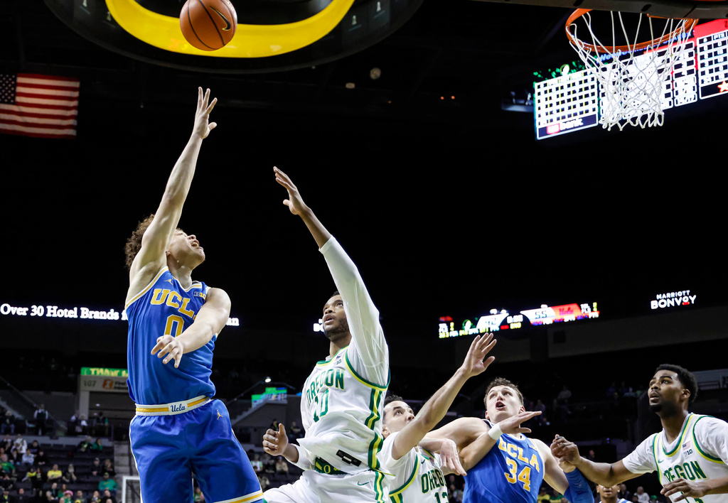 UCLA guard Trent Perry (0) shoots against Oregon forward Kwame Evans Jr. (10) in the second half of an NCAA college basketball game in Eugene, Ore., Wednesday, Jan. 28, 2026. (AP Photo/Thomas Boyd)
