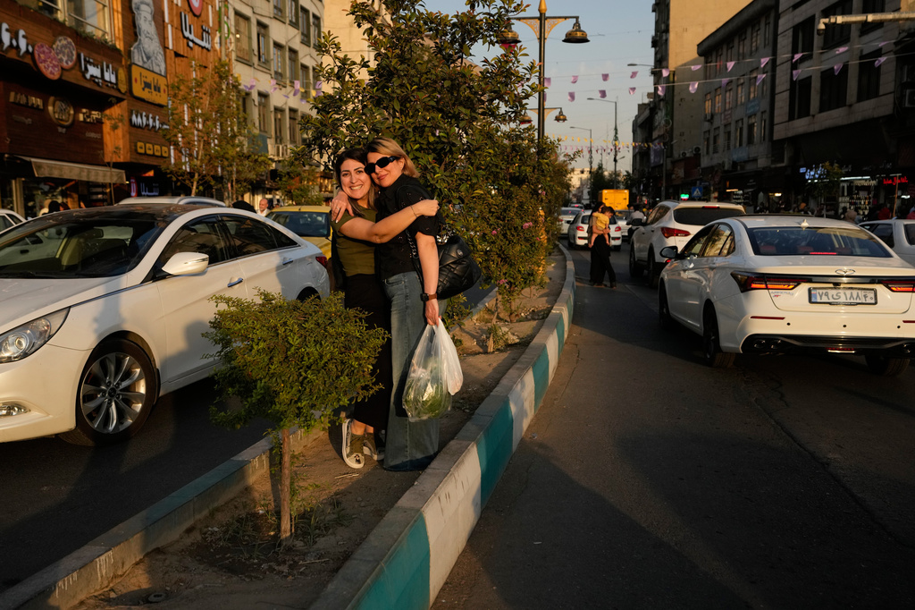 Women hug each other as they react to the camera at the Tajrish square in northern Tehran, Iran, Saturday, Sept. 12, 2026. (AP Photo/Vahid Salemi)
