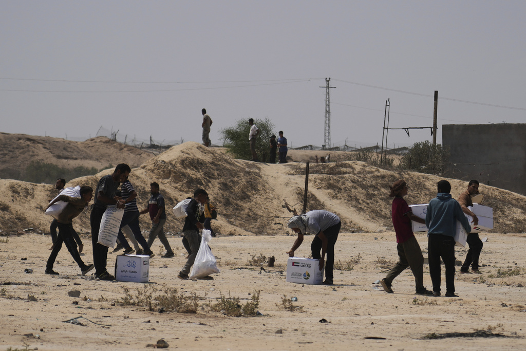 Palestinians collect humanitarian aid packages from the United Arab Emirates after they were airdropped into Deir al-Balah, in central Gaza Strip, Saturday, Aug. 9, 2025. (AP Photo/Abdel Kareem Hana)