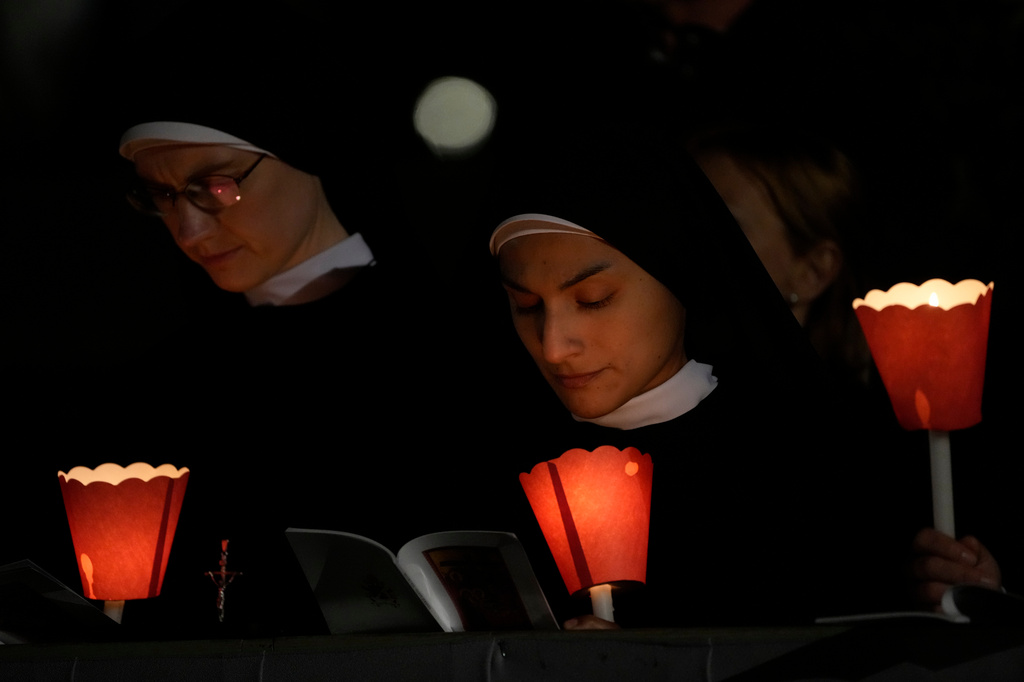 Faithful attend the Via Crucis, the torchlit Good Friday Stations of the Cross procession led by Pope Leo XIV at the Colosseum in Rome, Friday, April 3, 2026, which symbolically retraces Jesus Christ's steps to his crucifixion on Calvary in Jerusalem. (AP Photo/Gregorio Borgia)