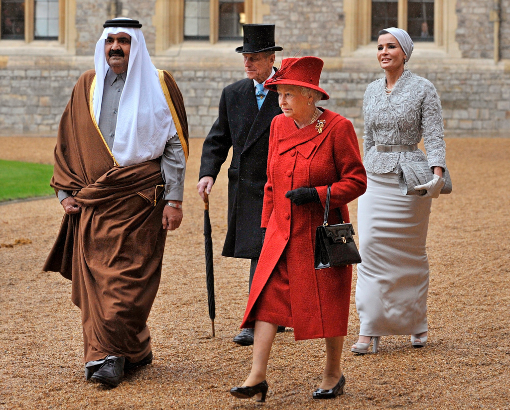 FILE - Emir of Qatar Sheikh Hamad bin Khalifa Al Thani, Britain's Prince Philip, Queen Elizabeth II and Sheika Mozah bint Nasser al-Missned walk during a welcoming ceremony at Windsor Castle, England, Oct. 26, 2010. (AP Photo/Stave Parsons, File)