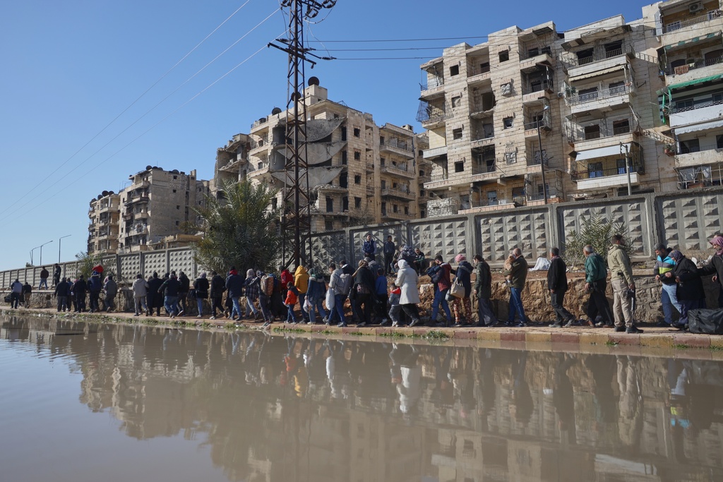 Civilians evacuate an area of the Sheikh Maqsoud neighborhood, where clashes between government forces and Kurdish fighters have been taking place in the northern city of Aleppo, Syria, Saturday, Jan. 10, 2026. (AP Photo/Omar Albam)