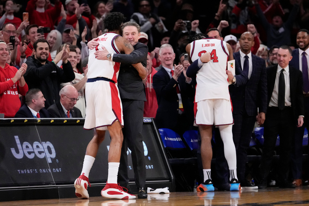 St. John's forward Dillon Mitchell (1) and St. John's head coach Rick Pitino embrace each other during the second half of an NCAA college basketball game against UConn in the championship of the Big East tournament, Saturday, March 14, 2026, in New York. (AP Photo/Yuki Iwamura)