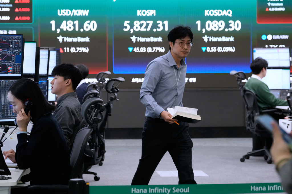 Currency traders work near a screen showing the Korea Composite Stock Price Index (KOSPI), top center, and the foreign exchange rate between U.S. dollar and South Korean won, top center left, at the foreign exchange dealing room of the Hana Bank headquarters in Seoul, South Korea, Thursday, April 9, 2026. (AP Photo/Ahn Young-joon)