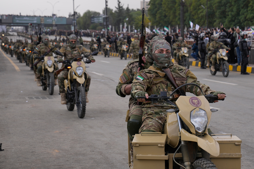 New Syrian army ride their motorcycles during a parade marking the first anniversary of the ousting of former President Bashar Assad in Damascus, Syria, Monday, Dec. 8, 2025. (AP Photo/Hussein Malla)