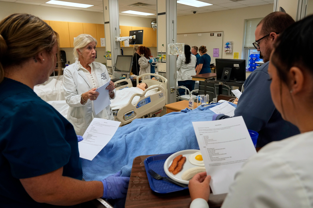 Nursing Instructor Sherry Troop, back left, speaks to nursing students in the simulation lab at Forsyth Technical Community College in Winston-Salem, N.C., Thursday, Aug. 20, 2026. (AP Photo/Chuck Burton)