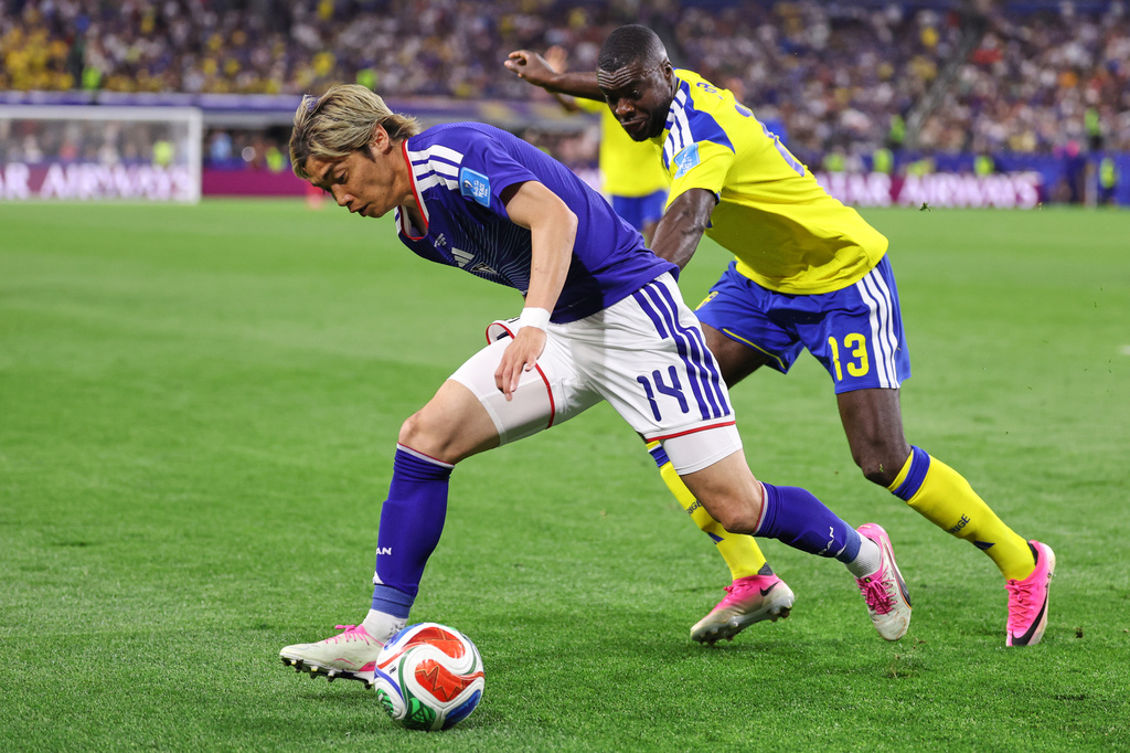 Japan's Junya Ito (14) and Sweden's Ken Sema (13) battle for the ball during the World Cup Group F soccer match between Japan and Sweden in Arlington, Texas, near Dallas, Thursday, June 25, 2026. (AP Photo/Sam Hodde)
