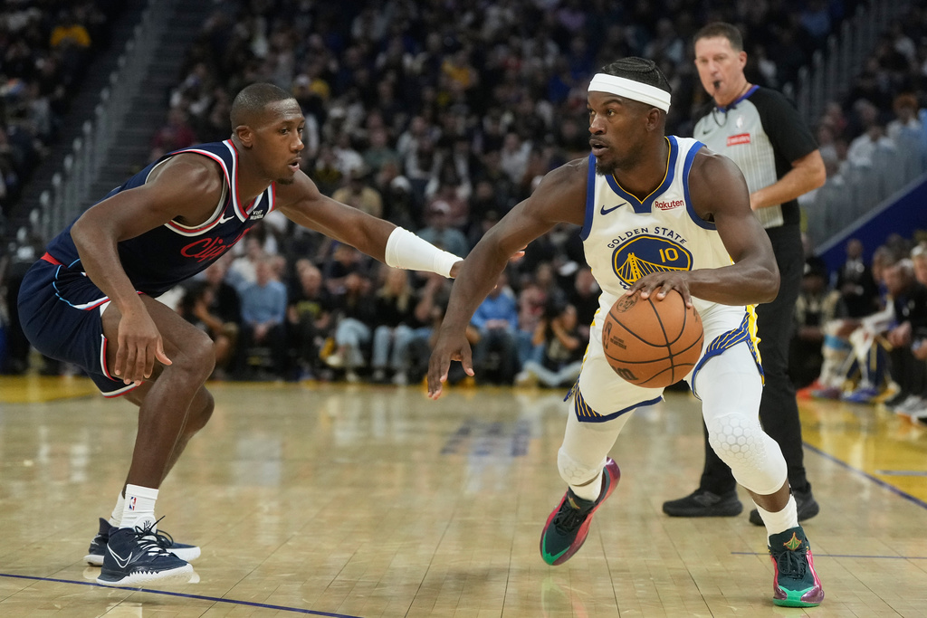 Golden State Warriors forward Jimmy Butler III (10) drives to the basket against Los Angeles Clippers guard Kris Dunn during the first half of an NBA basketball game in San Francisco, Tuesday, Oct. 28, 2025. (AP Photo/Jeff Chiu)