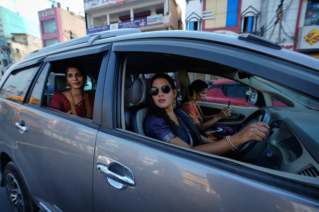 Nazariya Kutty, 28, left, with her friends drive to the Koothandavar temple to perform rituals during the Koovagam transgender festival in Villupuram, in the southern Indian state of Tamil Nadu, Tuesday, April 28, 2026. (AP Photo/Mahesh Kumar A.)