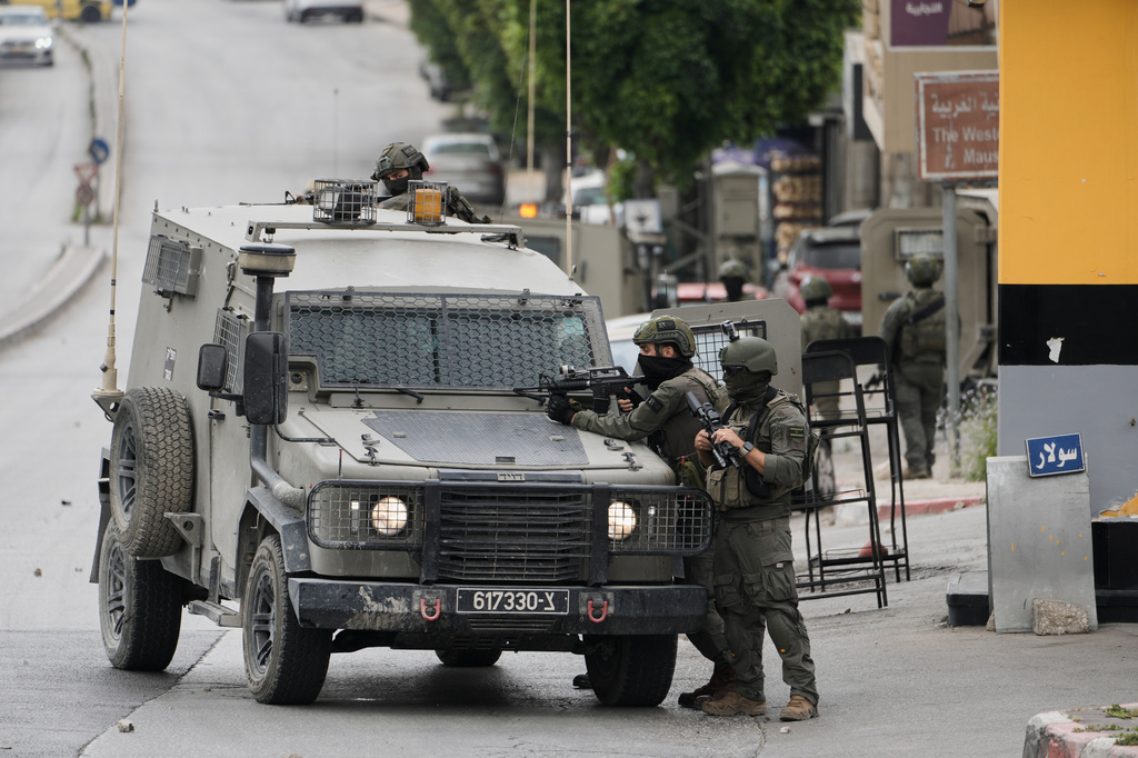 Israeli soldiers take positions during clashes with Palestinians in the West Bank city of Nablus, Sunday, May 3, 2026. (AP Photo/Majdi Mohammed)