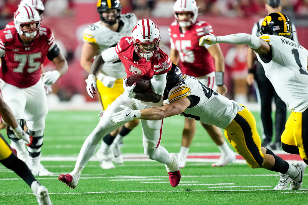 Wisconsin running back Dilin Jones (7) runs against Iowa linebacker Karson Sharar, center right, during the first half of an NCAA college football game Saturday, Oct. 11, 2025, in Madison, Wis. (AP Photo/Andy Manis)