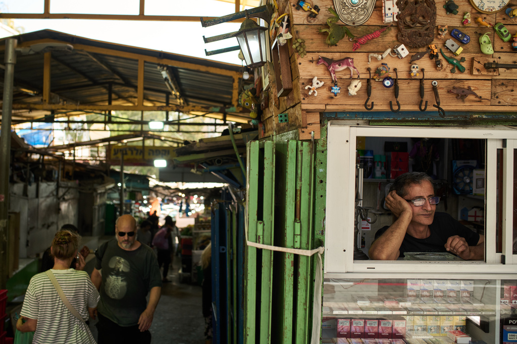A vendor looks on from the window of his shop at a local street market following air raid sirens warning of incoming Iranian missiles in Haifa, northern Israel, Monday, June 8, 2026. (AP Photo/Leo Correa)