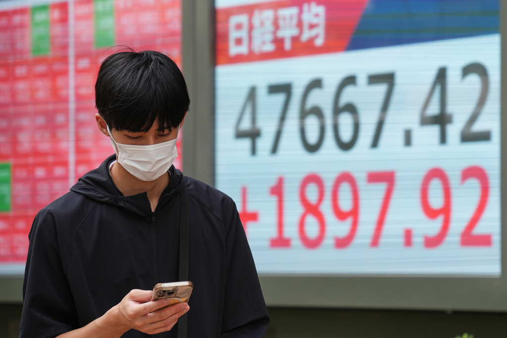 A person walks in front of an electronic stock board showing Japan's Nikkei index at a securities firm Monday, Oct. 6, 2025, in Tokyo. (AP Photo/Eugene Hoshiko)