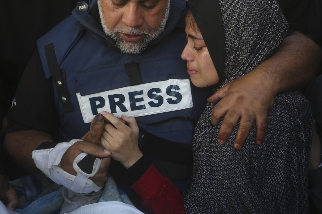 FILE - Al Jazeera journalist Wael Dahdouh holds the hand of his son, Hamza, who also worked for Al Jazeera and was killed in an Israeli airstrike, in Rafah, Gaza Strip, Jan. 7, 2024. (AP Photo/Hatem Ali, File)