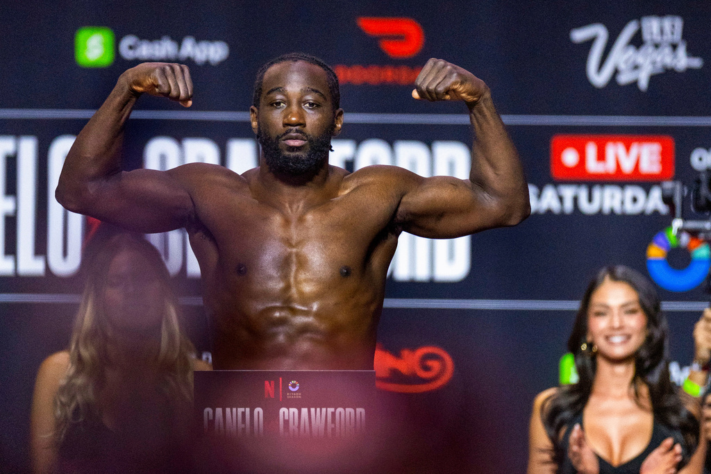 Super middleweight championship fighter Terence Crawford flexes on the scale for the crowd during weigh-ins for his fight against Canelo Alvarez, Friday, Sept. 12, 2025, in Las Vegas ahead of their scheduled Saturday bout. (AP Photo/L.E. Baskow)/Las Vegas Review-Journal via AP)