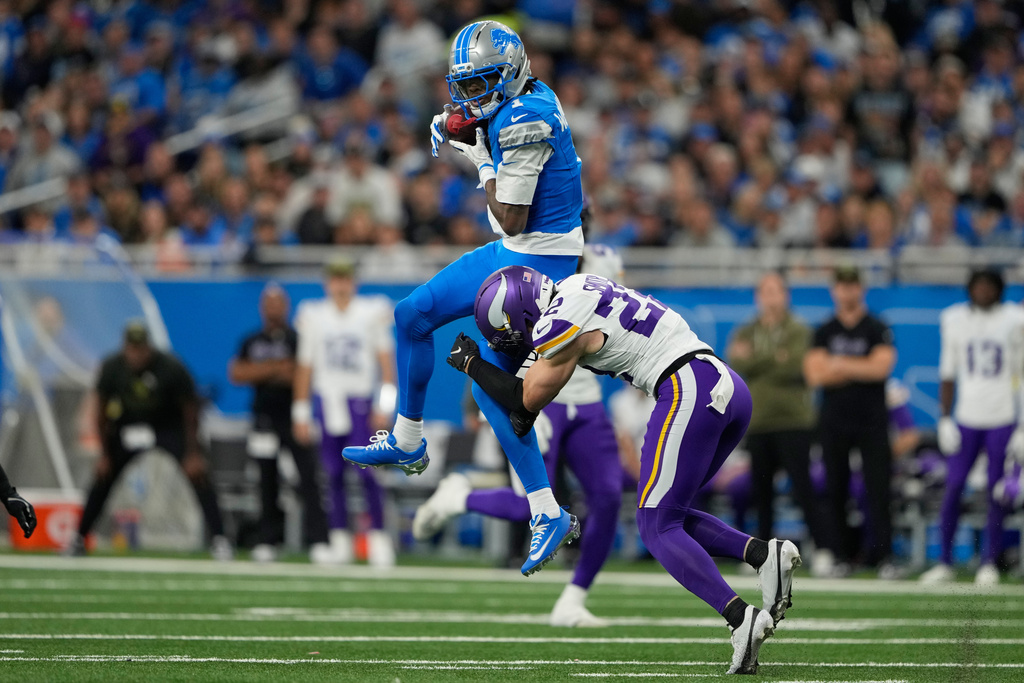 Detroit Lions wide receiver Jameson Williams (1) catches a pass as Minnesota Vikings safety Harrison Smith (22) tries to tackle during the second half of an NFL football game Sunday, Nov. 2, 2025, in Detroit. (AP Photo/Ryan Sun)