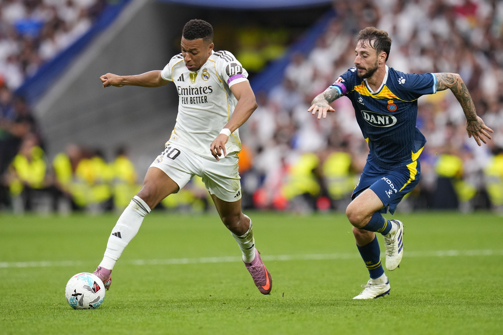 Real Madrid's Kylian Mbappe, left, and Espanyol's Fernando Calero challenge for the ball during the Spanish La Liga soccer match between Real Madrid and Espanyol at the Santiago Bernabeu stadium in Madrid, Spain, Saturday, Sept. 20, 2025. (AP Photo/Manu Fernandez)