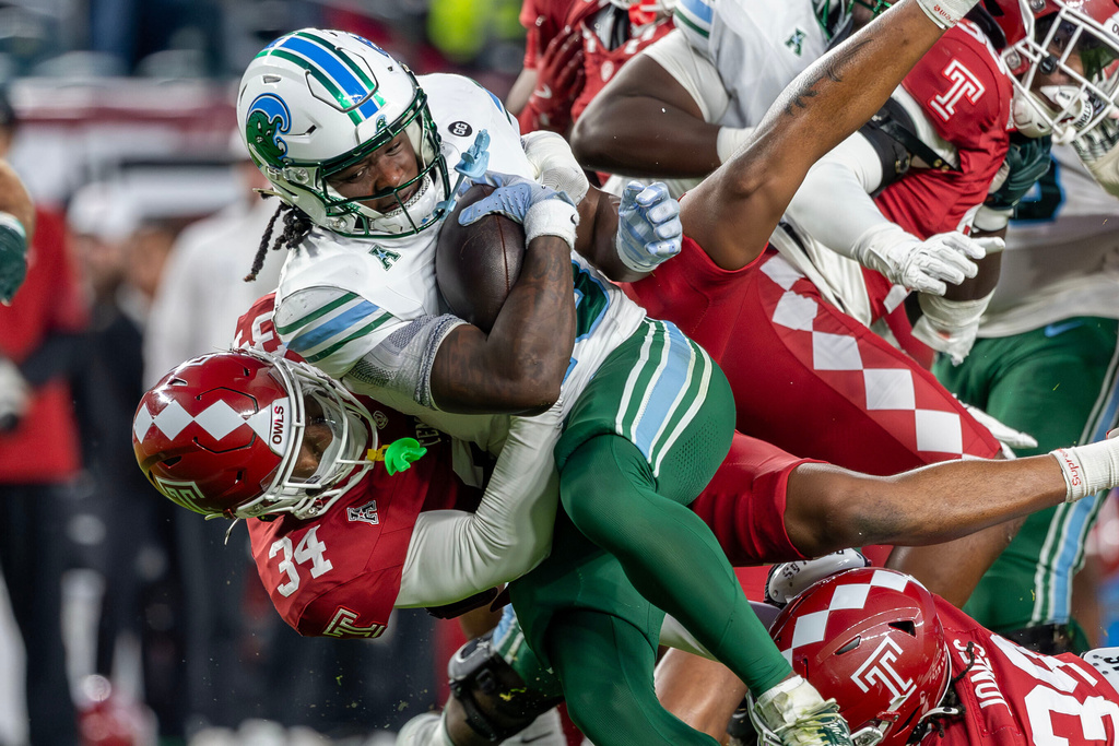 Tulane running back Jamauri McClure (25) is tackled by Temple linebacker London Hall (34) during the first half of an NCAA college football game, Saturday, Nov. 22, 2025, in Philadelphia. (AP Photo/Laurence Kesterson)