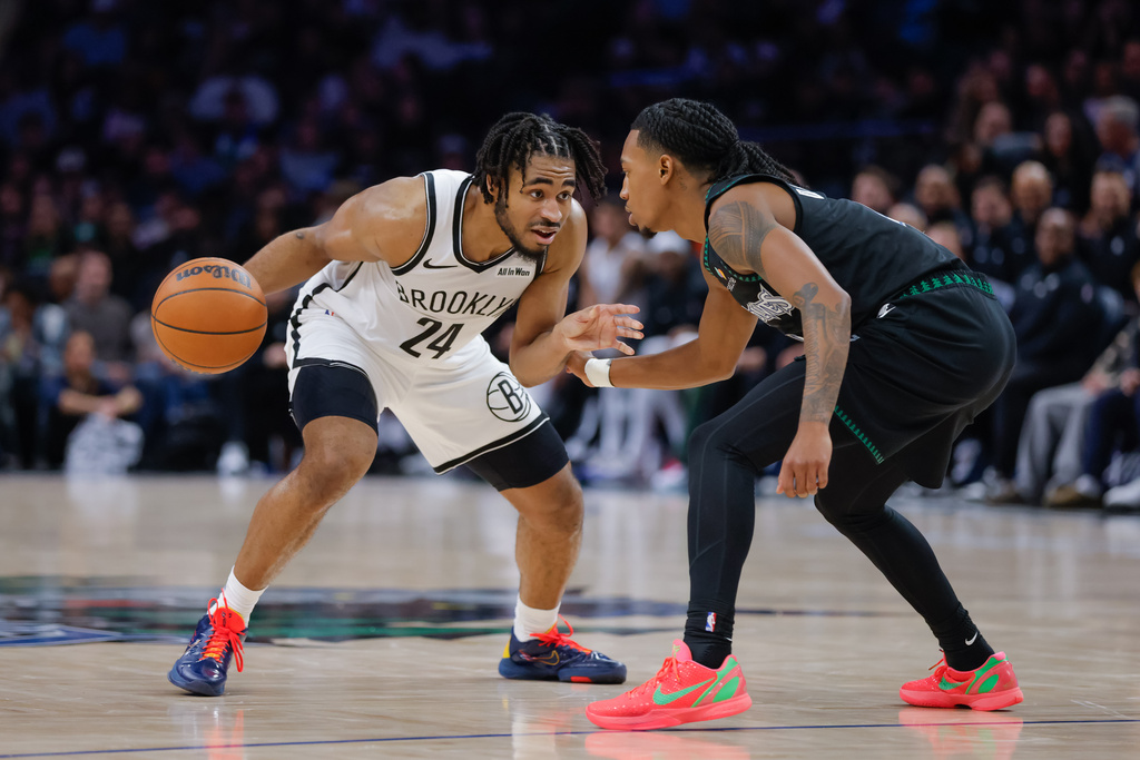 Brooklyn Nets guard Cam Thomas (24) handles the ball while Minnesota Timberwolves guard Rob Dillingham, right, defends during the second half of an NBA basketball game, Saturday, Dec. 27, 2025, in Minneapolis. (AP Photo/Bailey Hillesheim)