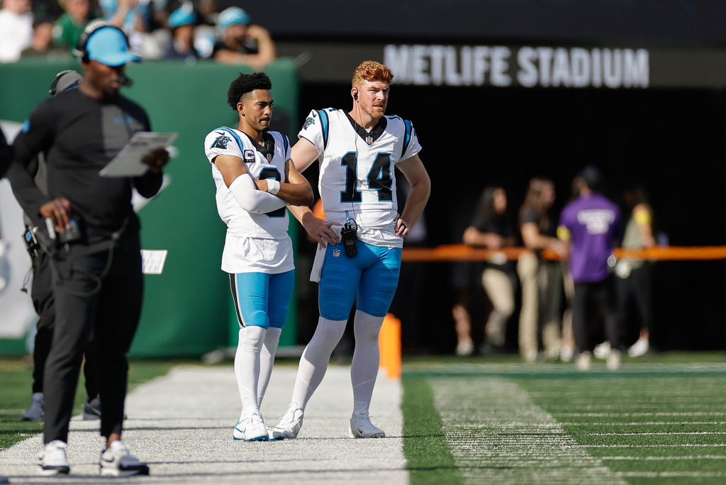 Carolina Panthers quarterback Bryce Young (9) and quarterback Andy Dalton (14) watch play against the New York Jets during the second quarter of an NFL football game, Sunday, Oct. 19, 2025, in East Rutherford, N.J. (AP Photo/Adam Hunger)