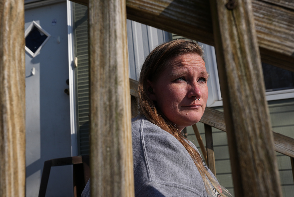 Dianna Tompkins sits on a stair in front of her home in Demotte, Ind., Dec. 17, 2025. (AP Photo/Nam Y. Huh)