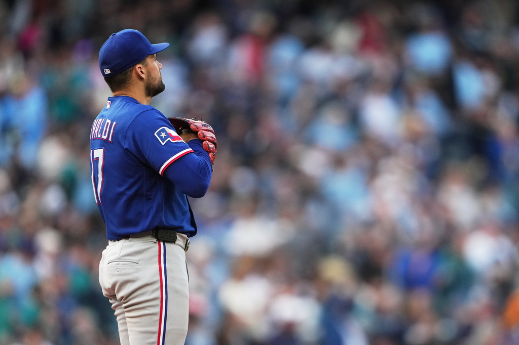 Texas Rangers starting pitcher Nathan Eovaldi looks to the outfield after allowing a solo home run against Seattle Mariners' Luke Raley during the sixth inning of a baseball game, Saturday, April 18, 2026, in Seattle. (AP Photo/Lindsey Wasson)