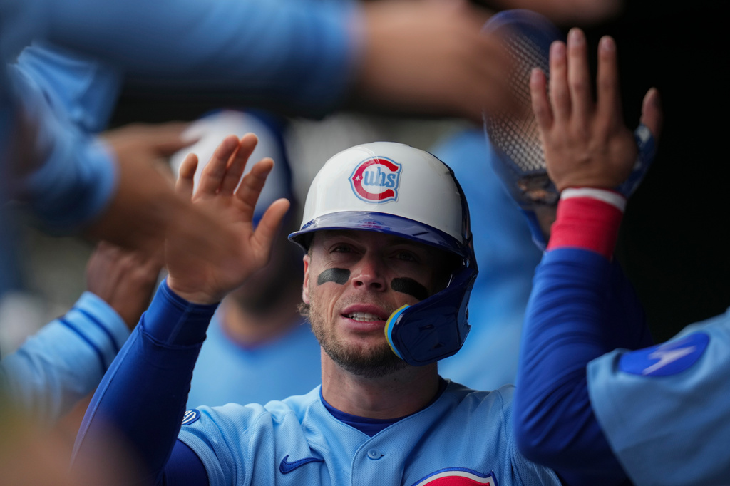 Chicago Cubs' Nico Hoerner (2) celebrates in the dugout after scoring on a single by Michael Busch during the first inning of a baseball game against the Arizona Diamondbacks, Friday, May 1, 2026, in Chicago. (AP Photo/Erin Hooley)