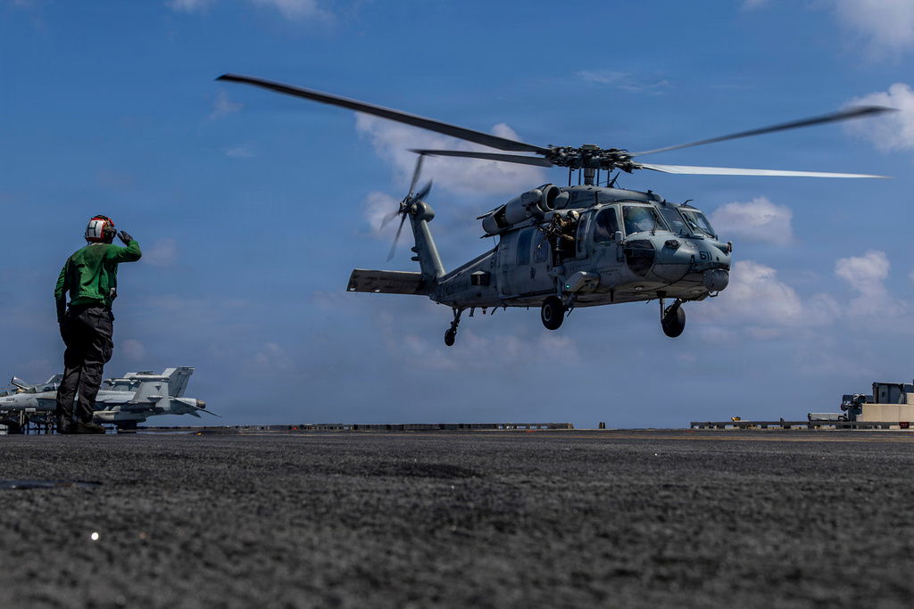 This handout image from the U.S. Navy shows Capt. Daniel Keeler, the commanding officer of the Nimitz-class aircraft carrier USS Abraham Lincoln, flying an MH-60R Sea Hawk helicopter in the Indian Ocean on Jan. 23, 2026. (Mass Communication Specialist Seaman Daniel Kimmelman/U.S. Navy via AP)