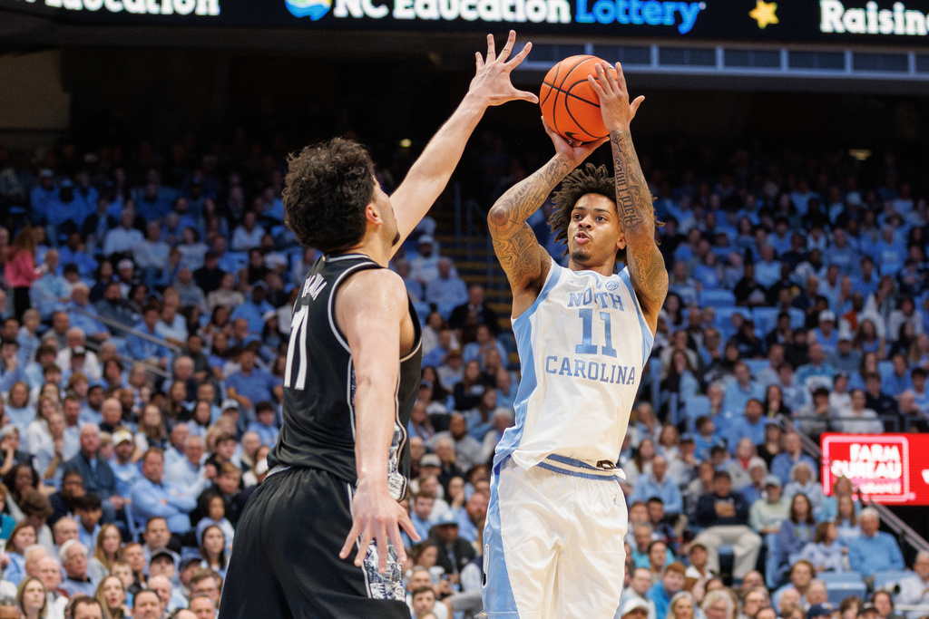 North Carolina's Jonathan Powell, right, attempts to shoot over Georgetown's Julius Halaifonua, left, during the first half of an NCAA college basketball game in Chapel Hill, N.C., Sunday, Dec. 7, 2025. (AP Photo/Ben McKeown)