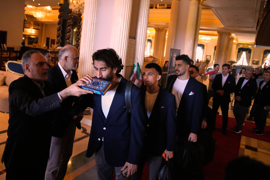 Iran's players kiss the Muslim's holiest book Quran as they leave to Antalya airport, southern Turkey, Saturday, June 6, 2026, before departing to Tijuana, Mexico, for the World Cup soccer tournament. (AP Photo/Khalil Hamra)