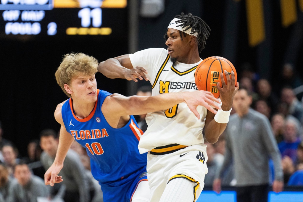 Florida's Thomas Haugh (10) tries to steal the ball from Missouri's Anthony Robinson II, right, during the first half of an NCAA basketball game Saturday, Jan. 3, 2026, in Columbia, Mo. (AP Photo/L.G. Patterson)