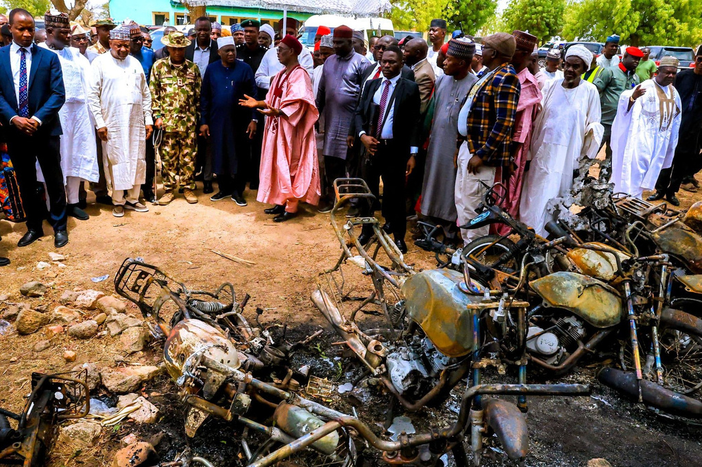 In this photo, released by Adamawa State Government House, Adamawa State Governor Ahmadu Umaru Fintiri, center left white hat, inspects an area in Guyaku, northeastern Nigeria, Monday, April 27, 2026, that was attacked by Militants with the Islamic State group on Sunday. (Adamawa state government house via AP)