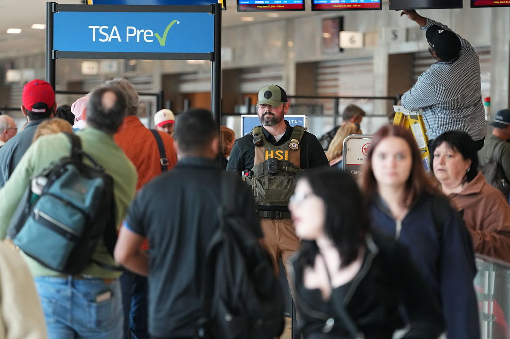 A federal officer, stands at a Transportation Security Administration (TSA) checkpoint at Philadelphia International Airport in Philadelphia, Friday, March 27, 2026. (AP Photo/Matt Rourke)