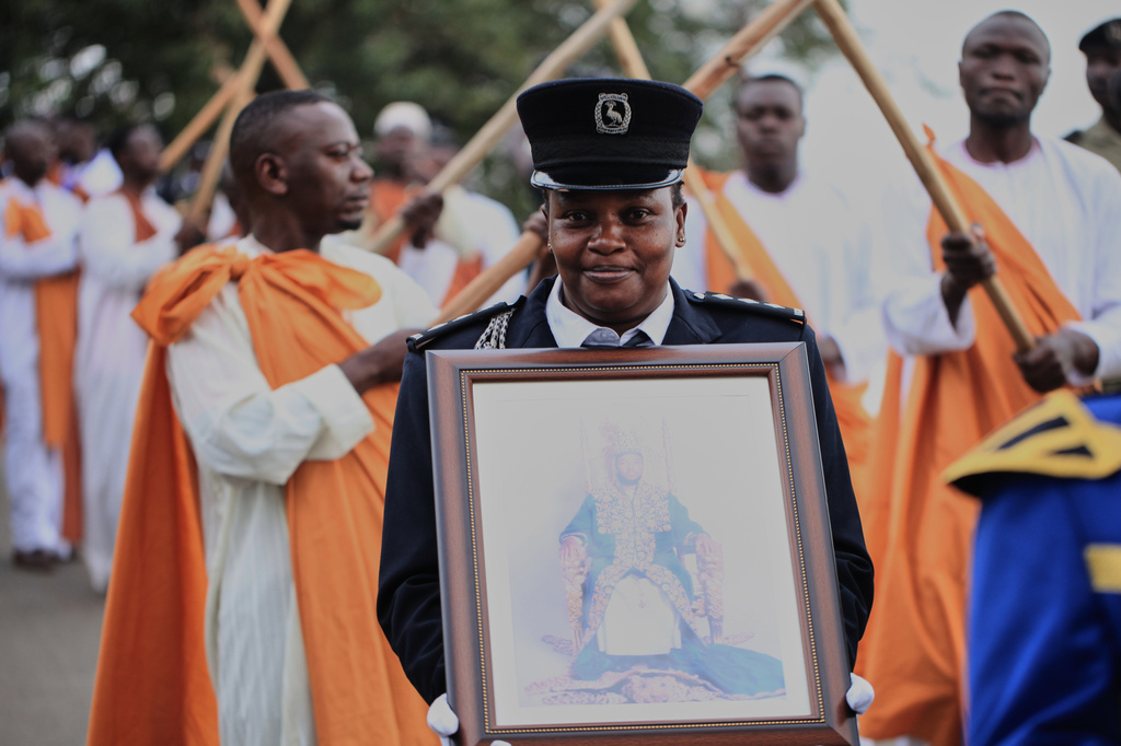 A Ugandan security officer carries a portrait of Tooro's King Oyo Nyimba during his funeral procession in Fort Portal, Uganda, Saturday, Sept. 12, 2026. (AP Photo/Patrick Onen)