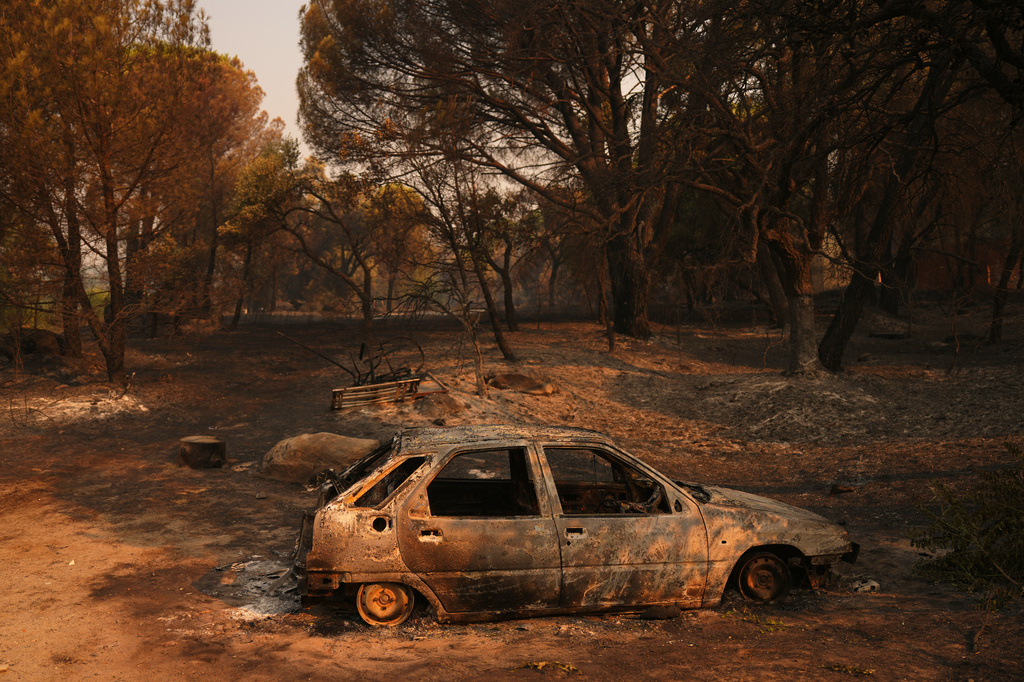 A car burned by a wildfire sits in Piedralaves, Ávila province, Spain, as the fire continues to spread, Tuesday, July 28, 2026. (AP Photo/Manu Fernandez)