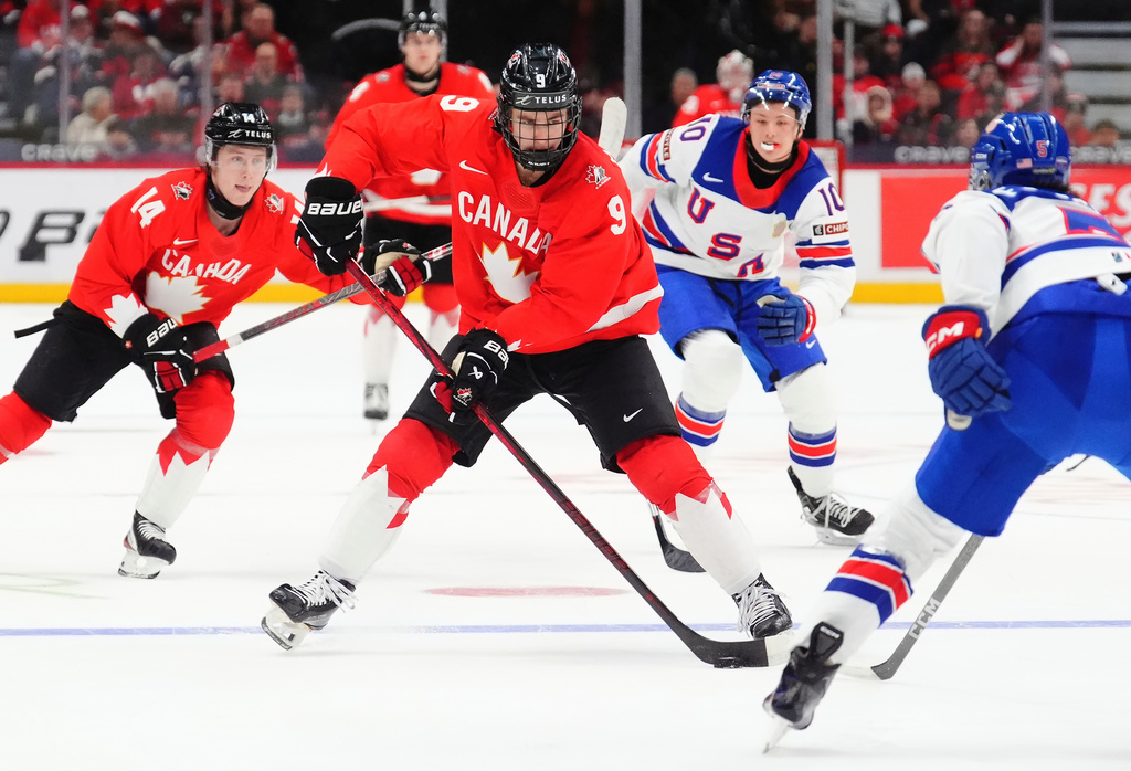 FILE - Canada's Gavin McKenna (9) skates with the puck as United States' Drew Fortescue (5) defends during the second period of an IIHF World Junior Hockey Championship tournament game in Ottawa, Ontario, Dec. 31, 2024. (Sean Kilpatrick/The Canadian Press via AP, File)