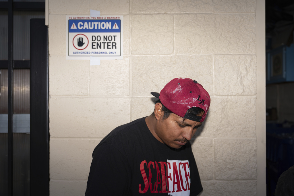 Day laborer Antonio, an immigrant from Guatemala, stands outside a day labor center in the parking lot of a Home Depot where a sign warns that law enforcement needs a warrant to enter, in Los Angeles, Friday, July 25, 2025. (AP Photo/Jae C. Hong)