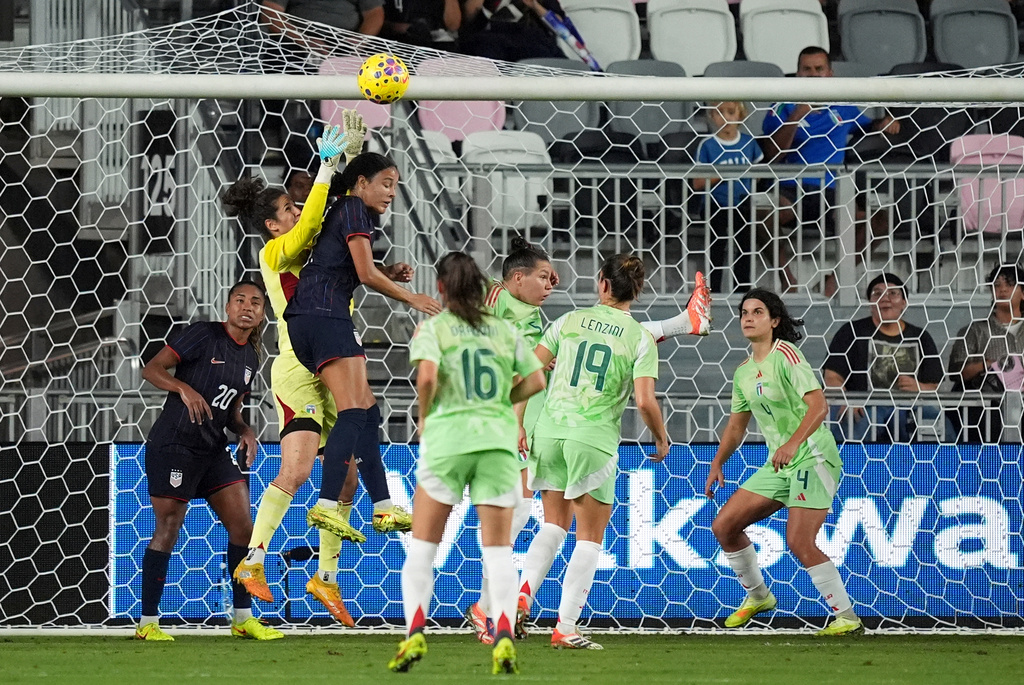 Italy goalkeeper Francesca Durante (22) jumps to deflect a shot against United States defender Jordyn Bugg (2) during the first half of an international friendly soccer match, Monday, Dec. 1, 2025, in Fort Lauderdale, Fla. (AP Photo/Rebecca Blackwell)