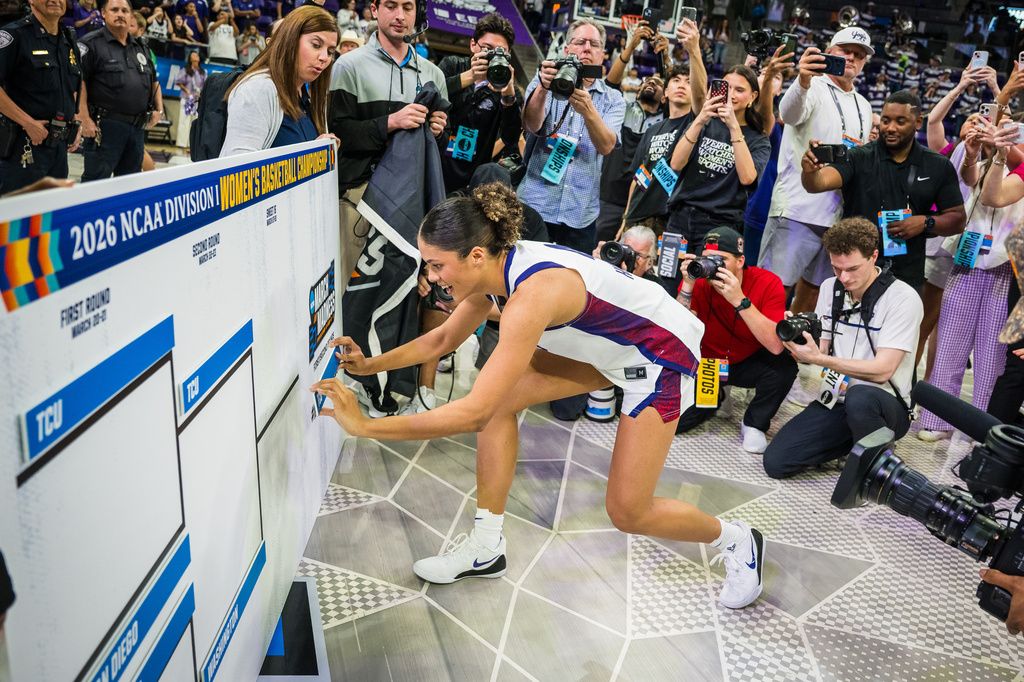 FILE - TCU guard Donovyn Hunter (4) places the team placard on the bracket board after the second round of the NCAA college basketball tournament March 22, 2026, Fort Worth, Texas. (AP Photo/Jessica Tobias, File)